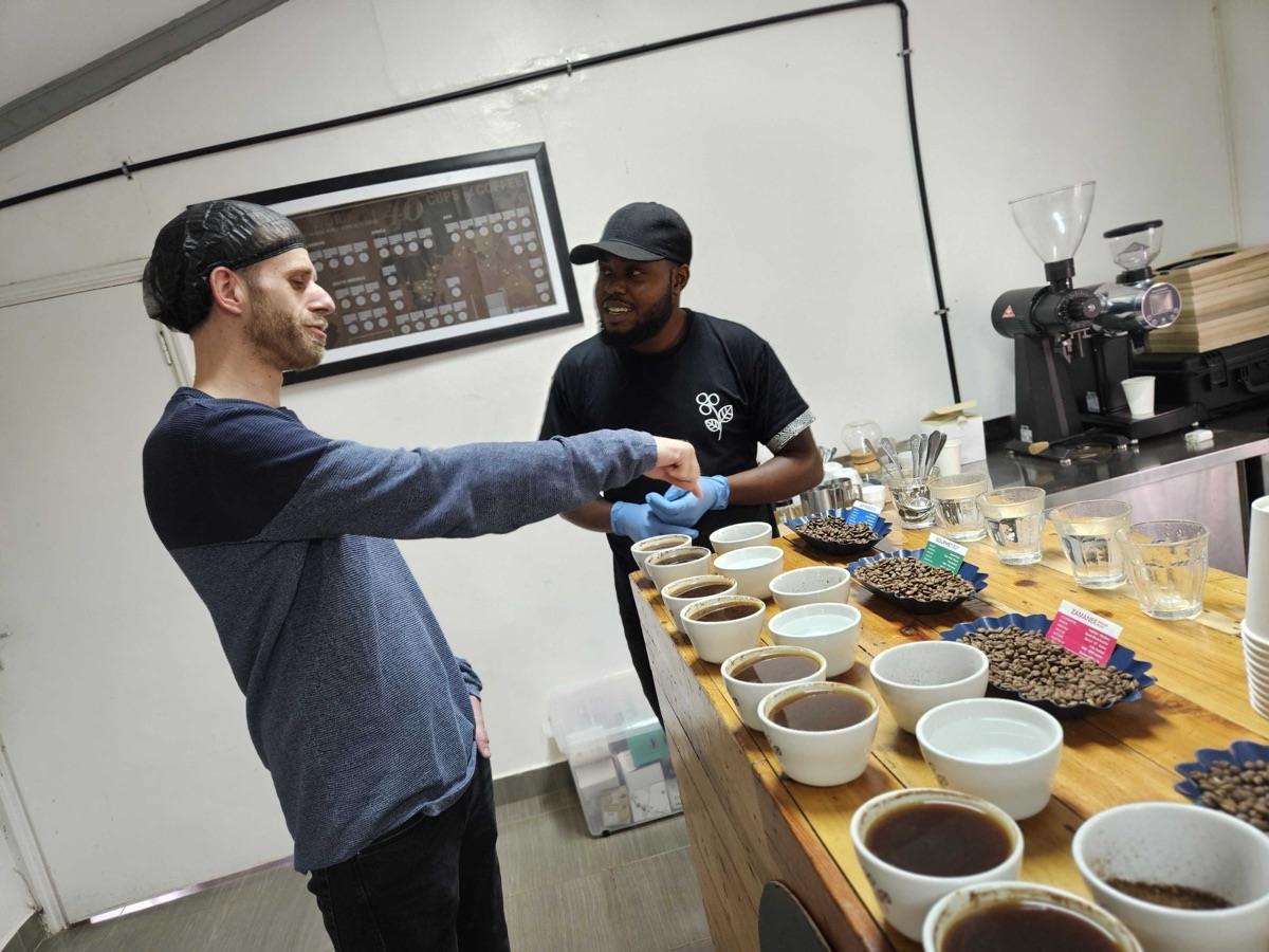 An Advance Insight consultant and a client at a coffee cupping table lined with samples